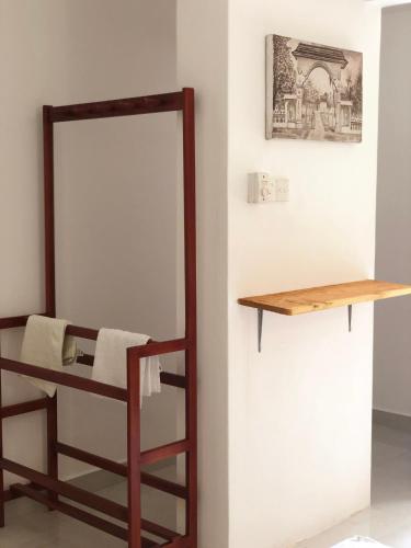 a room with a mirror and a shelf on a wall at The Retreat Hotel in Hikkaduwa