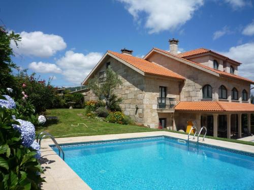 a house with a swimming pool in front of a house at Casa das Pías in Pías