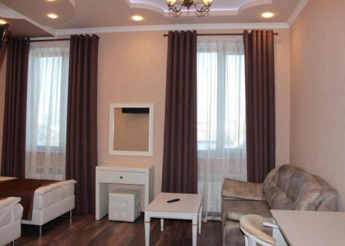a living room with a couch and a room with a bed at Hotel Ershov in Ishim