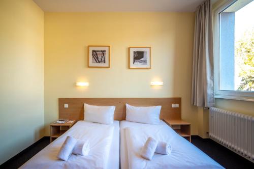 a bedroom with two beds and a window at Familienhotel Citylight in Berlin