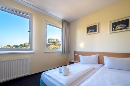 a hotel room with two beds and two windows at Familienhotel Citylight in Berlin