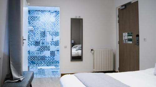 a bedroom with a blue and white glass door at Hôtel des Arcades in Reims