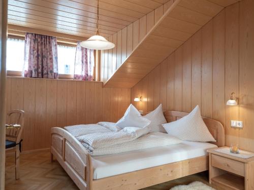 ein Schlafzimmer mit einem Bett in einer Holzwand in der Unterkunft Marenklhof in Welsberg-Taisten