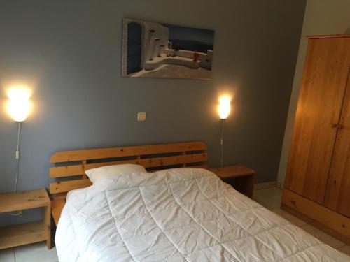 a bed in a bedroom with two lights on at à la belle vue in Rochehaut