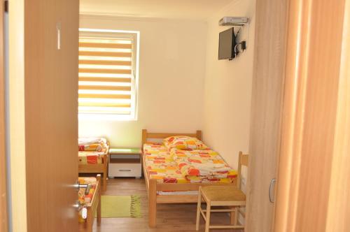 a small bedroom with a bed and a table at Apartments & Rooms Bojic in Kolašin