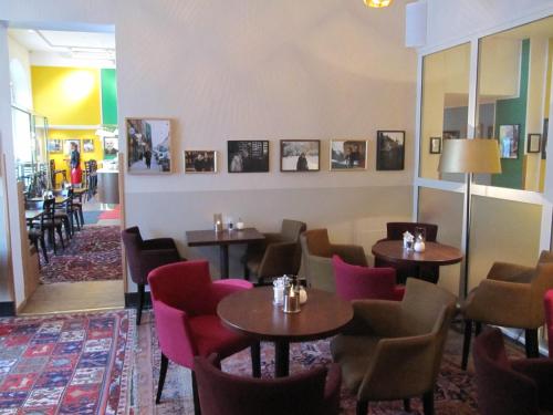 a restaurant with tables and chairs and pictures on the wall at Hotel Rival in Stockholm