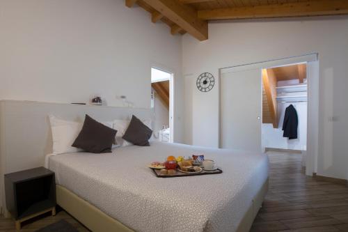 Un dormitorio con una cama con una bandeja de fruta. en BHL Boutique Rooms Legnano, en Legnano