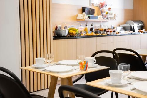 a dining room with tables and chairs and a counter at Hôtel Innes by HappyCulture in Toulouse