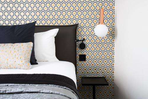 a bedroom with a bed and a black and white wall at Hôtel Innes by HappyCulture in Toulouse