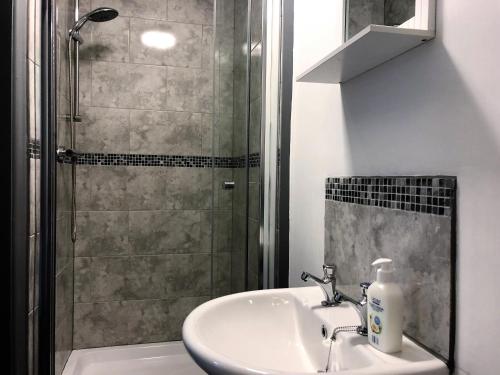 een badkamer met een wastafel en een douche bij No57 in Crewe
