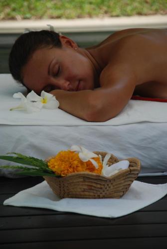 a man laying on a bed with a basket of flowers at The Park Samui in Choeng Mon Beach