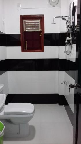 a black and white bathroom with a toilet and a window at The Green Village Dambulla in Dambulla