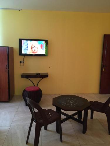a living room with chairs and a tv on a wall at Bob Apartments in Calodyne