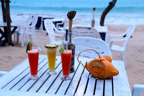 a table with drinks and fruit on the beach at Golden Surfer Beach Hotel in Tangalle