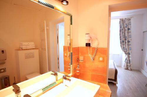 a bathroom with a sink and a large mirror at Hotel Royal Bon Repos in Sainte-Maxime