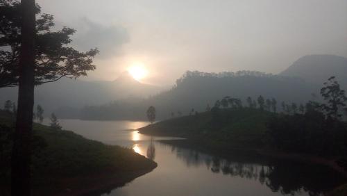 a view of a river with the sun in the background at Princess of Dickoya Homestay in Hatton