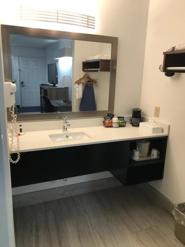 uma casa de banho com um lavatório e um espelho grande em Baymont by Wyndham Anderson Clemson em Anderson