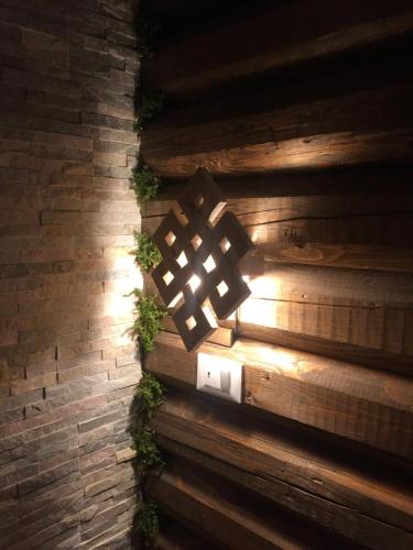 a light on a brick wall with plants on it at Eirl DOLOMITES Retreat Sappada in Sappada
