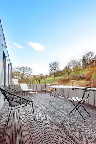 a deck with chairs and a table on a building at Vistay apartments in Luxembourg