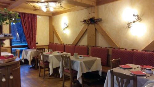 Albergo Garni Martina في كاريسولو: مطعم فيه طاولات وكراسي في الغرفة