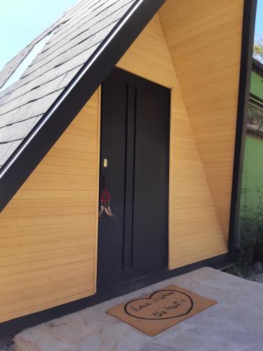 a black door of a house with a heart on it at La Quinta Glamping - Lago de Tota in Cuítiva