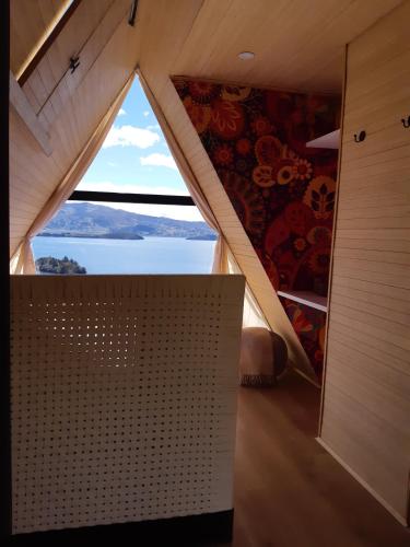 a room with a window with a view of the water at La Quinta Glamping - Lago de Tota in Cuítiva