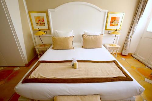 a bedroom with a large white bed in a room at Hotel Royal Bon Repos in Sainte-Maxime