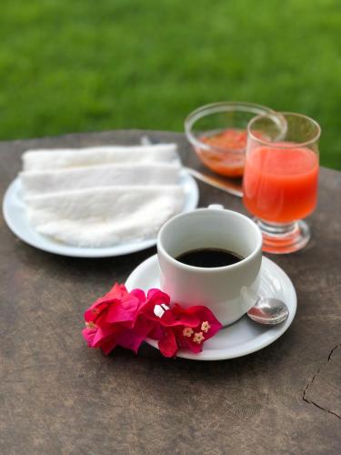 una tazza di caffè e un fiore sul tavolo di Pousada Maraoka a Porto De Galinhas