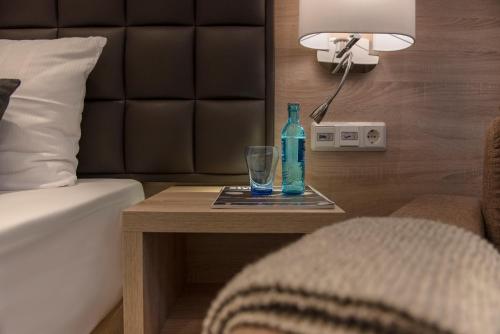 a bottle and a glass on a table in a hotel room at Hotel-Restaurant Barbarossahof in Kaiserslautern