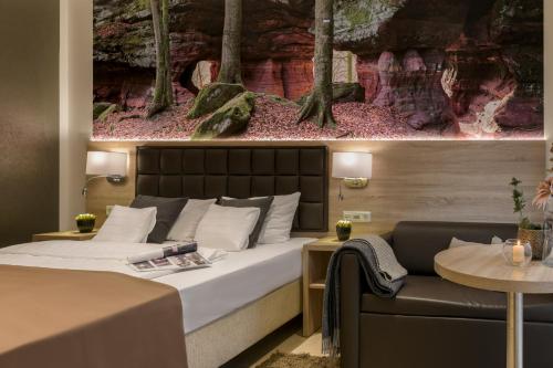 a hotel room with a bed and a couch at Hotel-Restaurant Barbarossahof in Kaiserslautern