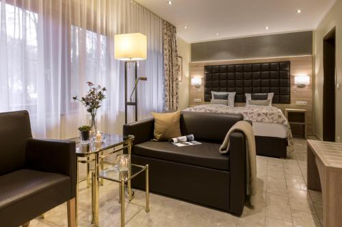 a hotel room with a bed and a couch at Hotel-Restaurant Barbarossahof in Kaiserslautern