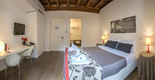 a bedroom with a bed and a desk and a television at Relais Fori Imperiali in Rome
