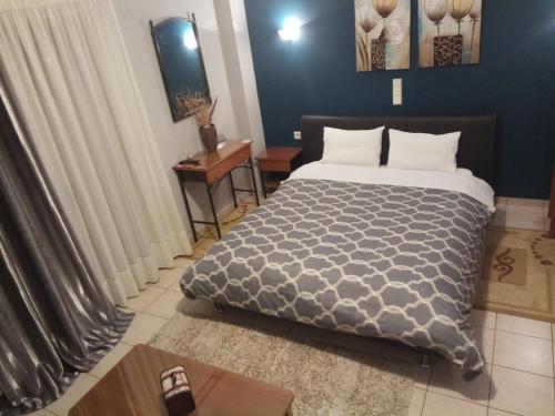 a bedroom with a bed and a blue wall at Zisis Garden Studios in Ioannina