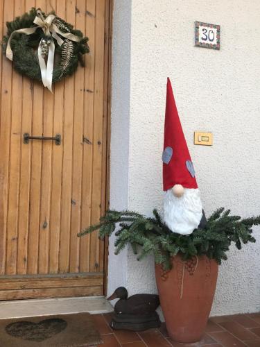 a pot with a gnome on it next to a door at La Casa di Isabella Loreto in Loreto