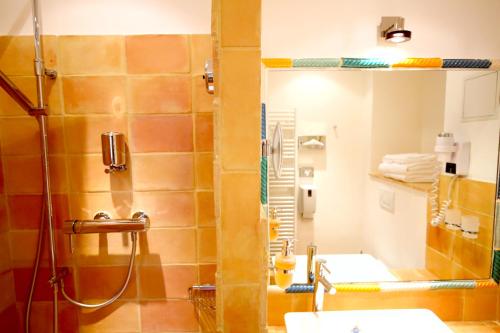 a bathroom with two sinks and a shower and a mirror at Hotel Royal Bon Repos in Sainte-Maxime