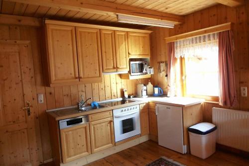 a kitchen with wooden cabinets and a white stove top oven at Bauernhof Hatzlhof in Schöder