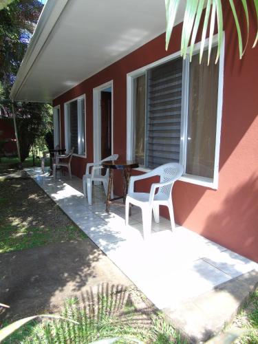 a patio with chairs and a table on a house at Posada Rural Río Celeste in Rio Celeste