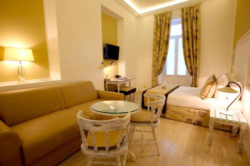 a living room with a couch and a bed and a table at Hotel Royal Bon Repos in Sainte-Maxime
