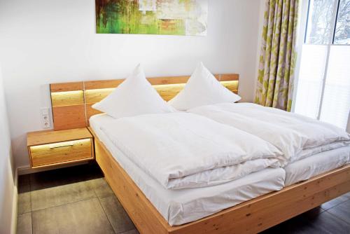 ビンツにあるFerienappartement mit Balkon im Osのベッドルーム1室(白いシーツと枕のベッド1台付)