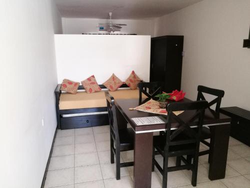 a dining room with a table and chairs and a bed at departamento centro in La Rioja