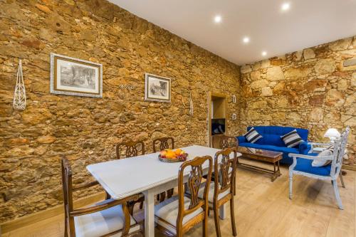 a dining room with a stone wall and a table and chairs at Villas Marim in Olhão