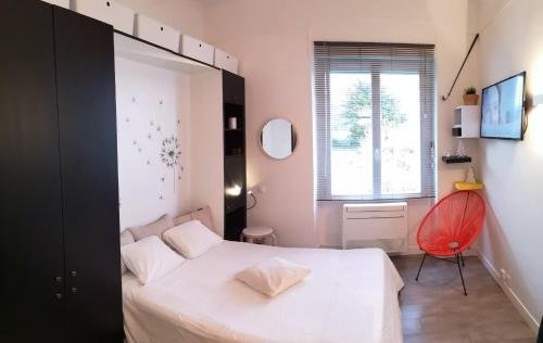 ビアリッツにあるStudio Privé Résidence Reginaのベッドルーム(白いベッド1台、赤い椅子付)