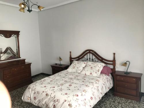 sypialnia z łóżkiem, 2 komodami i lustrem w obiekcie Bonito piso en el centro de Benaguacil w mieście Benaguacil