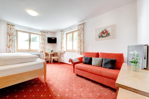 una camera d'albergo con letto e divano di Hotel Gasthof KREUZ a Sonntag