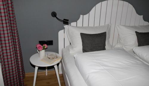 a bedroom with a bed and a nightstand with a table at Ferienwohnungen im Färberhaus in Fischen