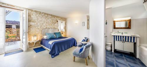 a bedroom with a bed and a bathroom with a window at Les Vents Bleus in Donnazac
