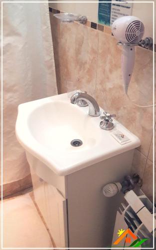 a white sink in a bathroom with a hair dryer at Meraki Las Heras in Las Heras