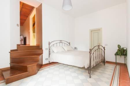 a white bedroom with a bed and a staircase at Papavero Accademia Carrara in Bergamo