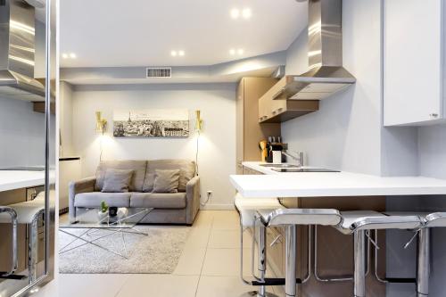 une cuisine et un salon avec un canapé dans l'établissement Habitat Parisien - Appartement Opéra Galeries Lafayette, à Paris