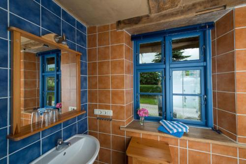 a bathroom with a tub and a sink and a window at Alte Schule Ludwigsburg in Loissin